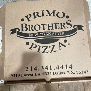 a person standing in front of a pizza box