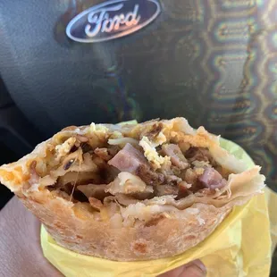 a hand holding a burrito