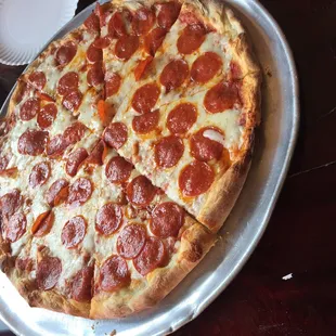 a pepperoni pizza on a pan