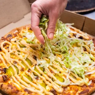 a person putting cheese on a pizza
