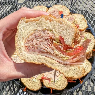 a person holding a sandwich on a plate