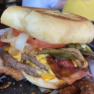 a burger with bacon, cheese, and onions