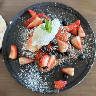 strawberries, blueberries, and powdered sugar on a plate