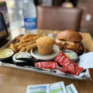 Chicken sandwich with greens, fries, and muffin