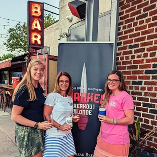 three women standing in front of a bar