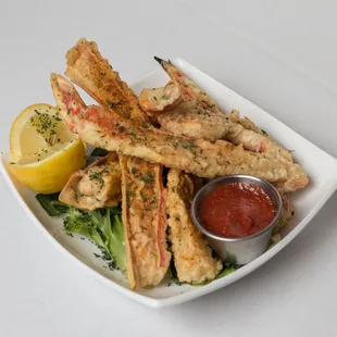 a plate of crab legs with a side of ketchup