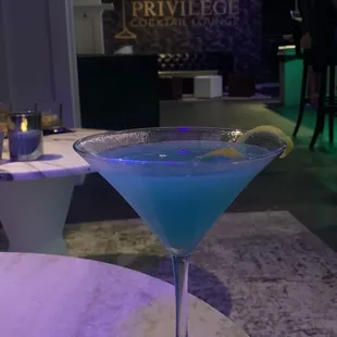 a blue cocktail in a martini glass