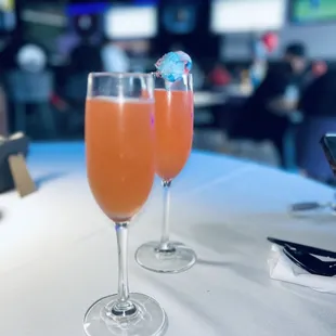 two glasses of orange juice on a table