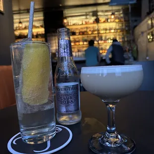 a drink and a bottle of gin on a table