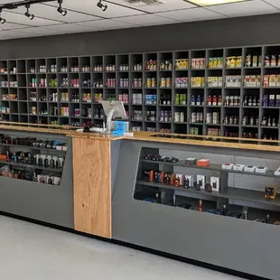 Our wall of E-liquid and Salt Nic with our cases of mods/tanks/kits