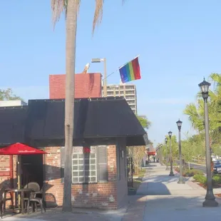 a view of a street with tables and umbrellas