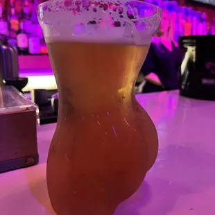 a glass of beer on a bar counter