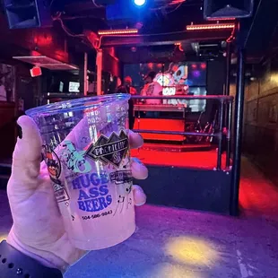 a person holding a cup of beer
