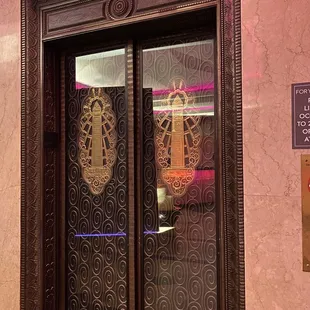 the reflection of a clock in a glass door
