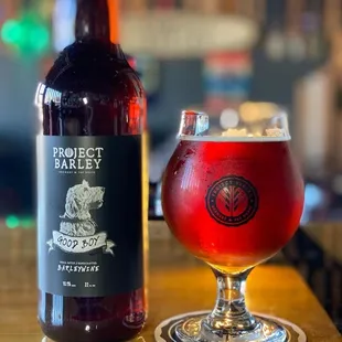 a glass of pizzeria next to a bottle of pizzeria