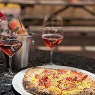 a plate of pizza and two glasses of wine