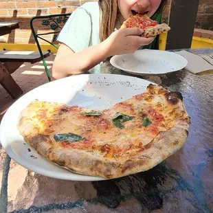 a young girl eating a slice of pizza