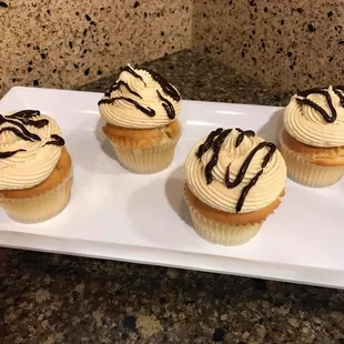 four cupcakes on a white plate