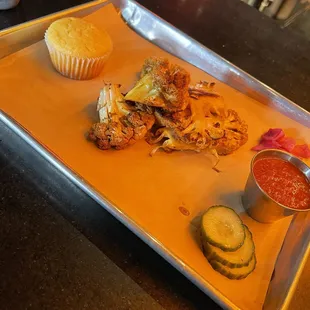 moroccan cauliflower steak, cornbread muffin, cucumbers, onions, proof sauce