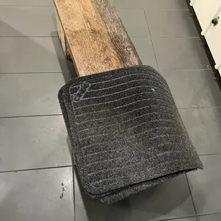 piss soaked urinal floor mat conveniently air drying on a bench you sit on, as one does, whilst mopping urinals with disgusting mop water