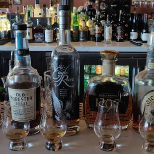 a variety of liquor bottles and glasses on a bar