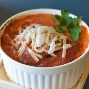 a bowl of soup with cheese on top