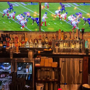 a bar with two televisions on the wall