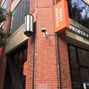 a brick building with a sign for proper food