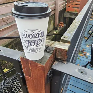 a coffee cup on a railing