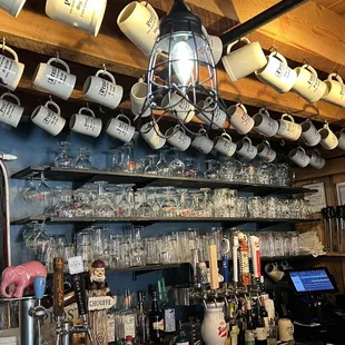 a shelf of mugs and glasses