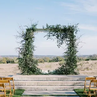An outdoor spring wedding ceremony on the lawn with lush greenery