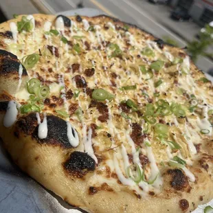 a pizza with cheese and green onions