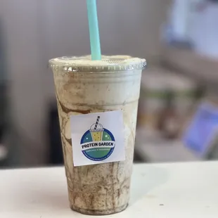 a drink in a plastic cup with a blue straw