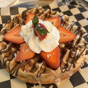 a waffle topped with strawberries and whipped cream