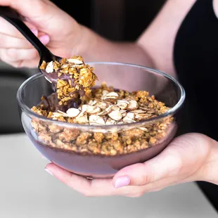 a woman eating a bowl of granola