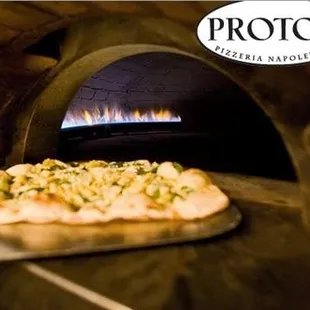 a pizza in front of an oven