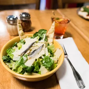 a bowl of salad with a fork and knife