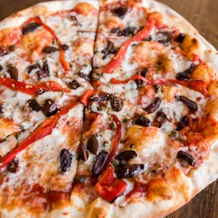 a pizza with pepperoni, olives, and cheese