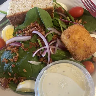 Spinach salad with fried goat cheese wheel and rosemary bread