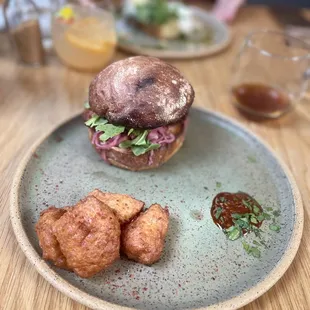 Korean fried chicken sando - Fried chicken, red cabbage and daikon kimchi slaw, gochujang sauce, served with pommes dauphines. $18.00