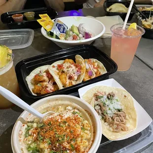 a variety of tacos and drinks on a table