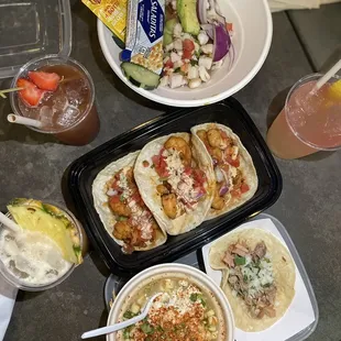 a variety of tacos and drinks on a table