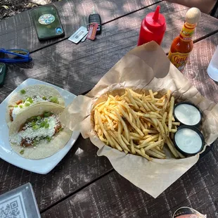 two tacos and fries on a picnic table