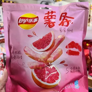 a hand holding a bag of frozen grapefruits