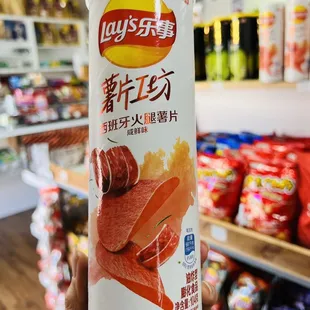 a hand holding a can of lay's