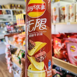 a hand holding a can of chips