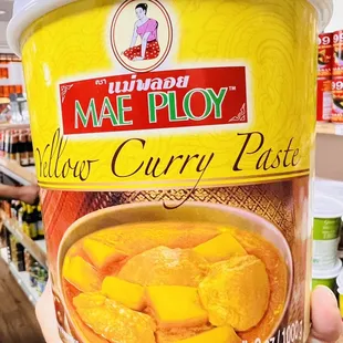 a hand holding a cup of curry paste