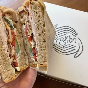a hand holding a sandwich