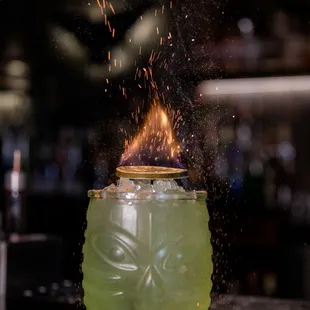 a green drink being sprinkled with fire