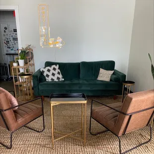 a living room with a green couch and chairs